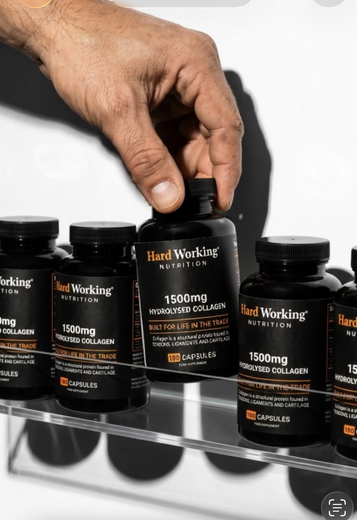 Hardworking hand reaching for Hard Working Nutrition bottle